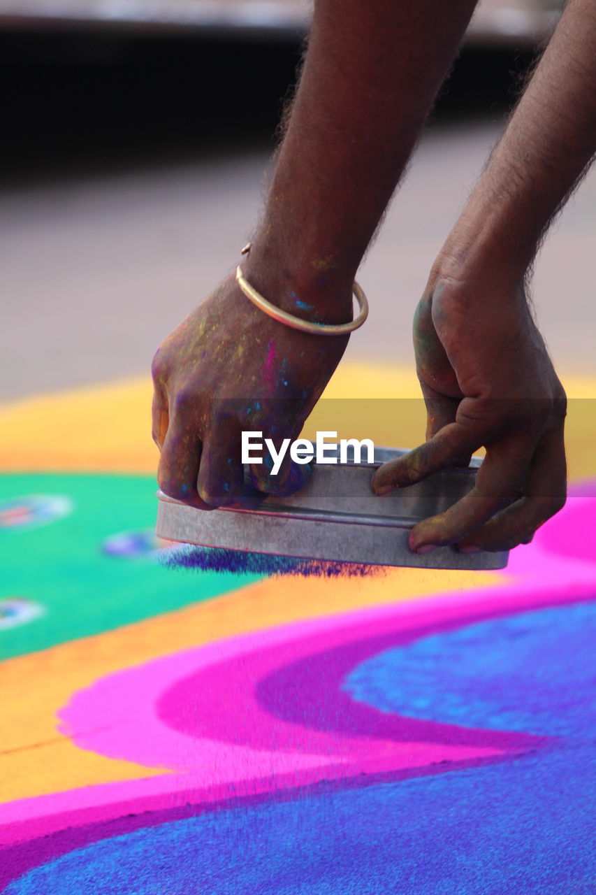 Cropped image of hands making rangoli