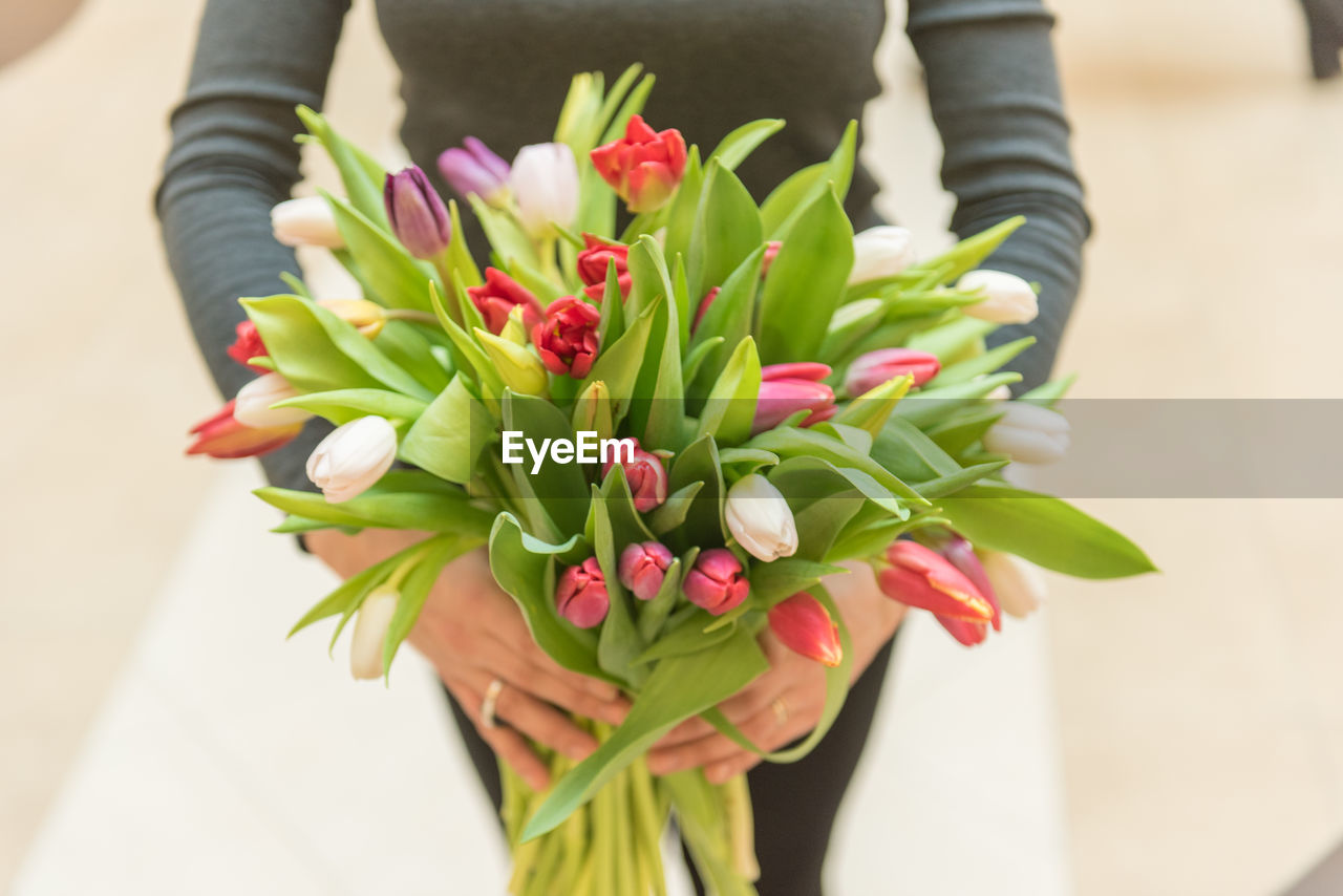 CLOSE-UP OF HAND HOLDING BOUQUET OF FLOWERS