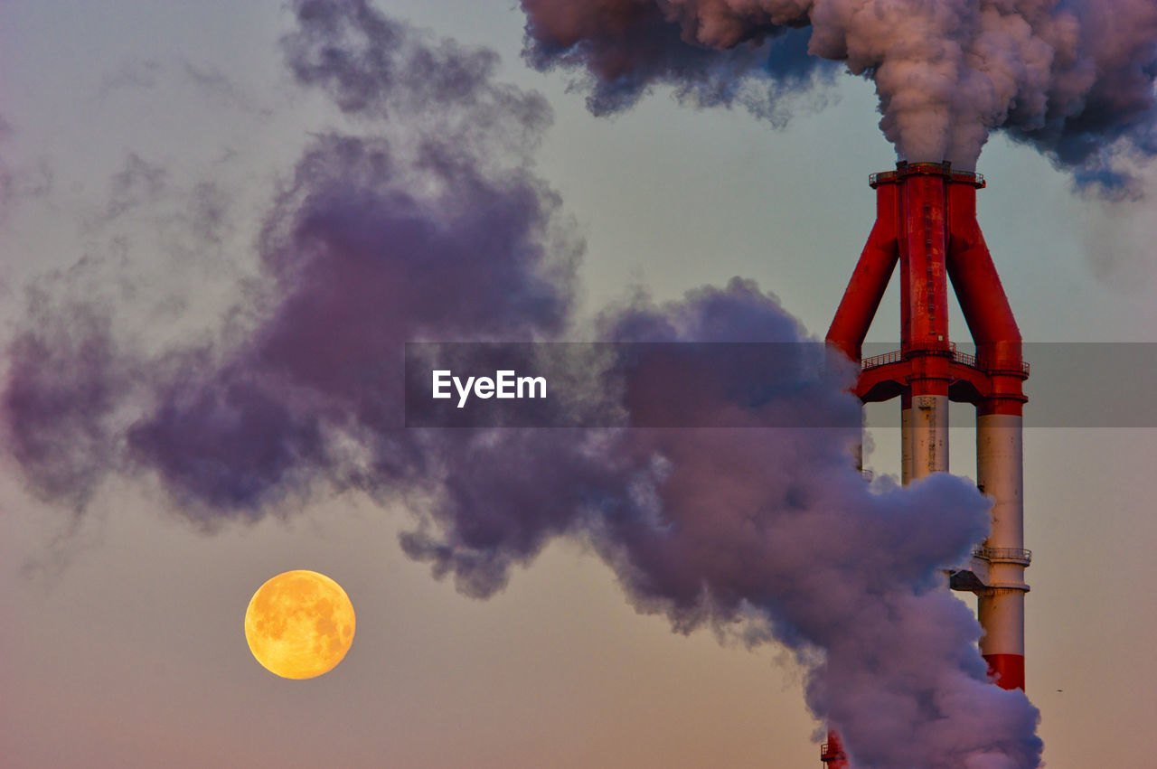 Smoke emitting from chimney against sky