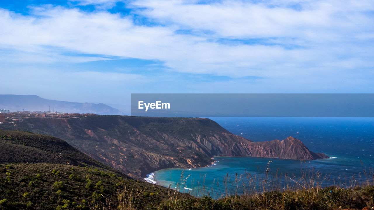 Idyllic shot of mountains in sea against sky