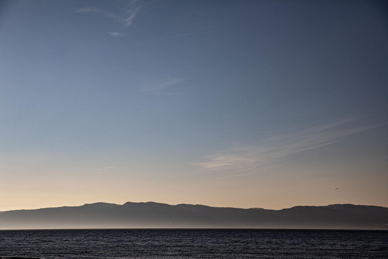 Tranquil view of trondheimsfjord  against sky during sunset.