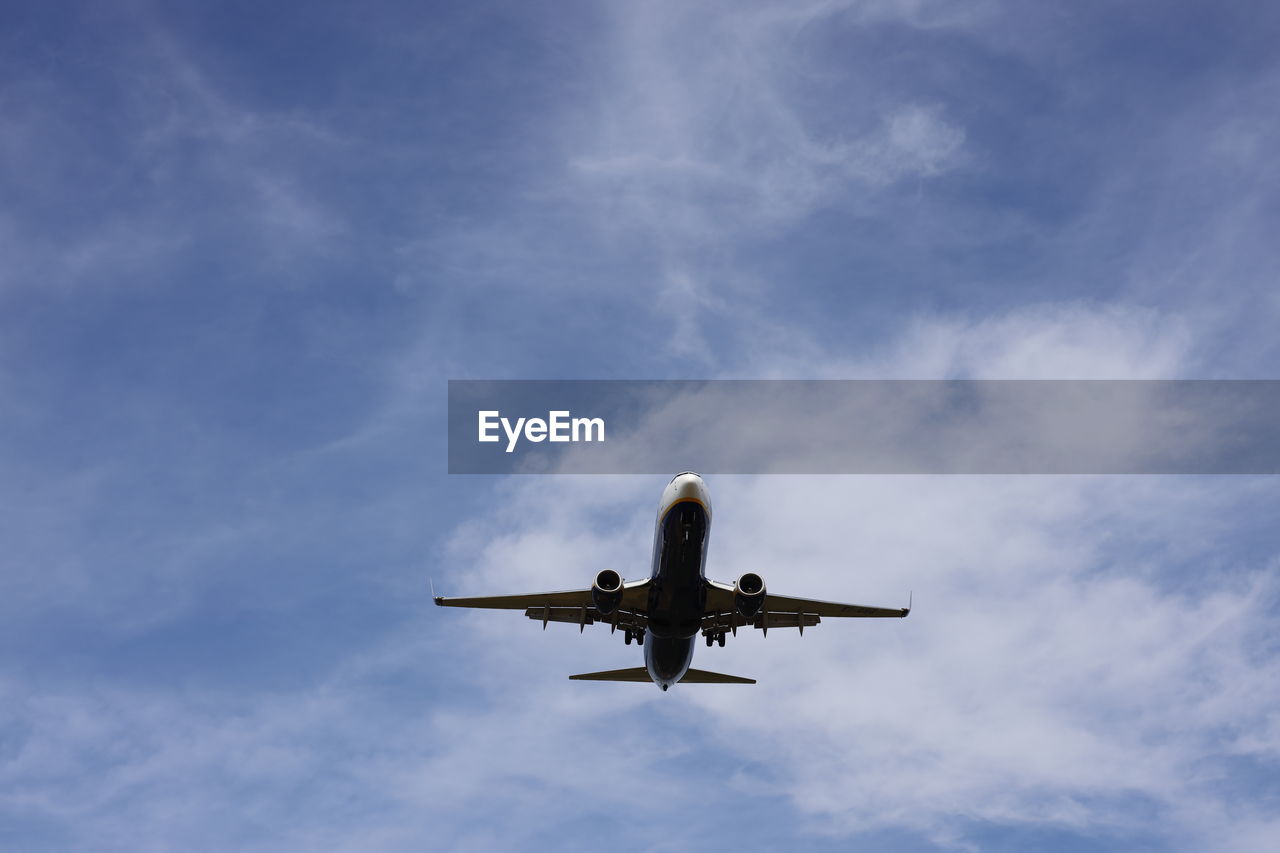 Low angle view of airplane flying against sky