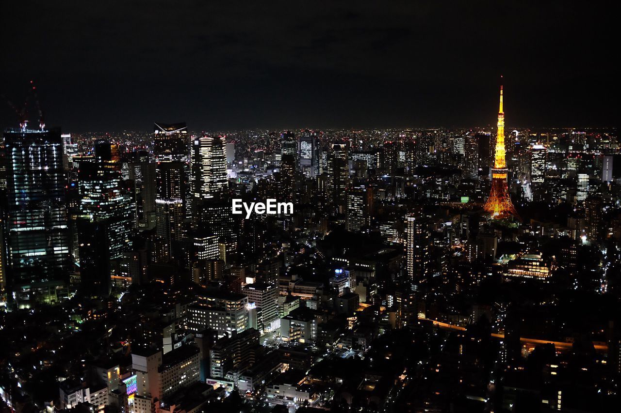 Exterior of modern illuminated cityscape against clear sky at night