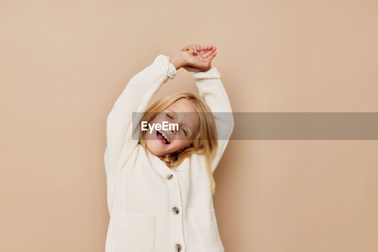 Portrait of smiling young woman against white background