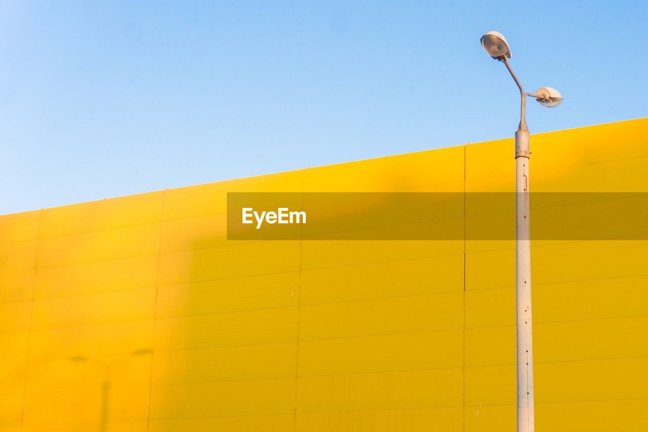 Low angle view of street light against yellow building