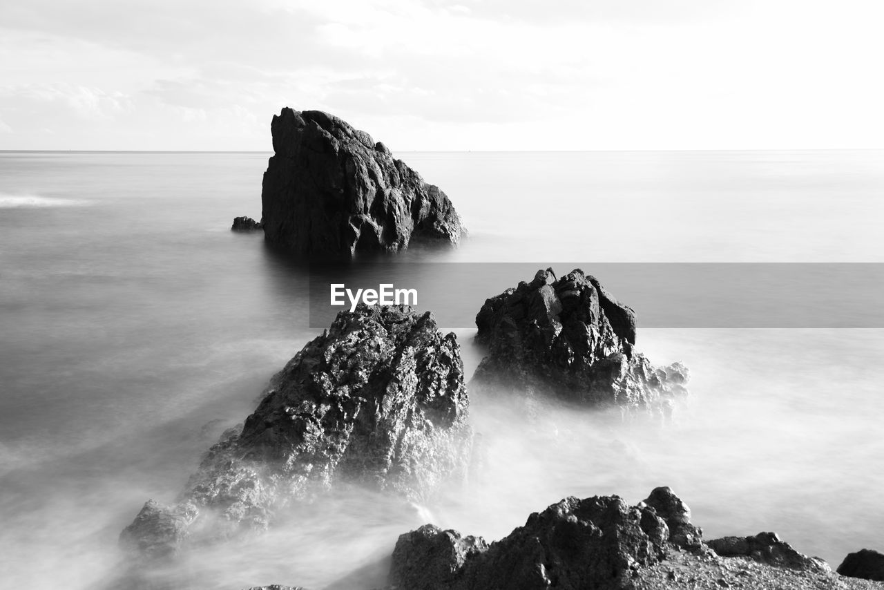 Scenic view of rock formation in sea against sky