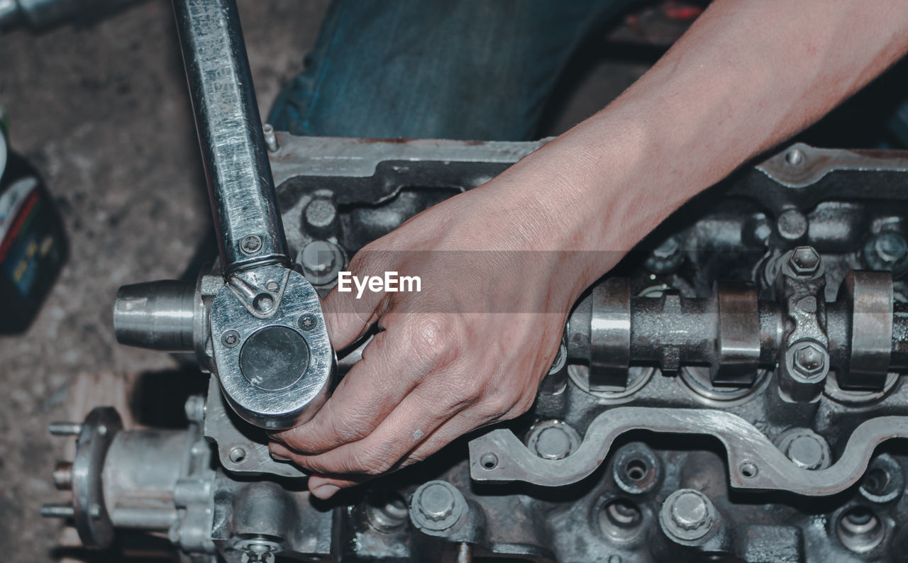 The mechanic is checking the engine.