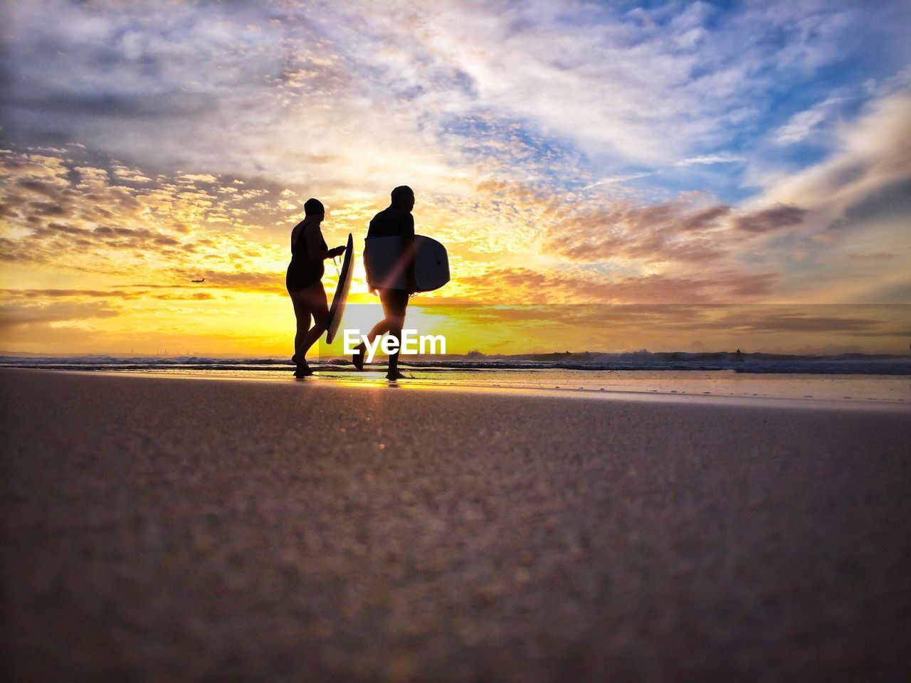 SILHOUETTE OF PEOPLE WALKING ON BEACH