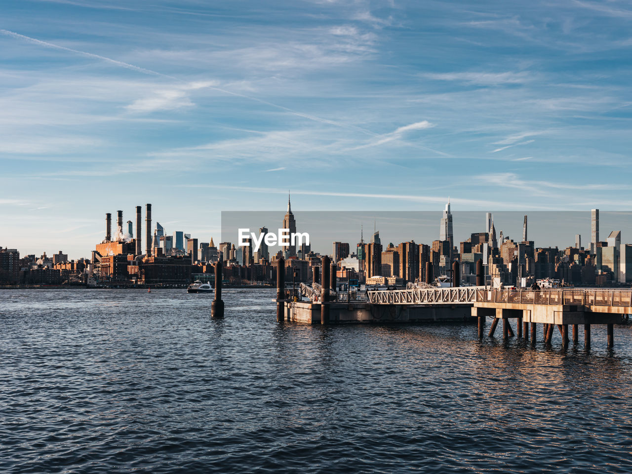 Sunset over east river midtown manhattan skyline and north 5th street pier at brooklyn