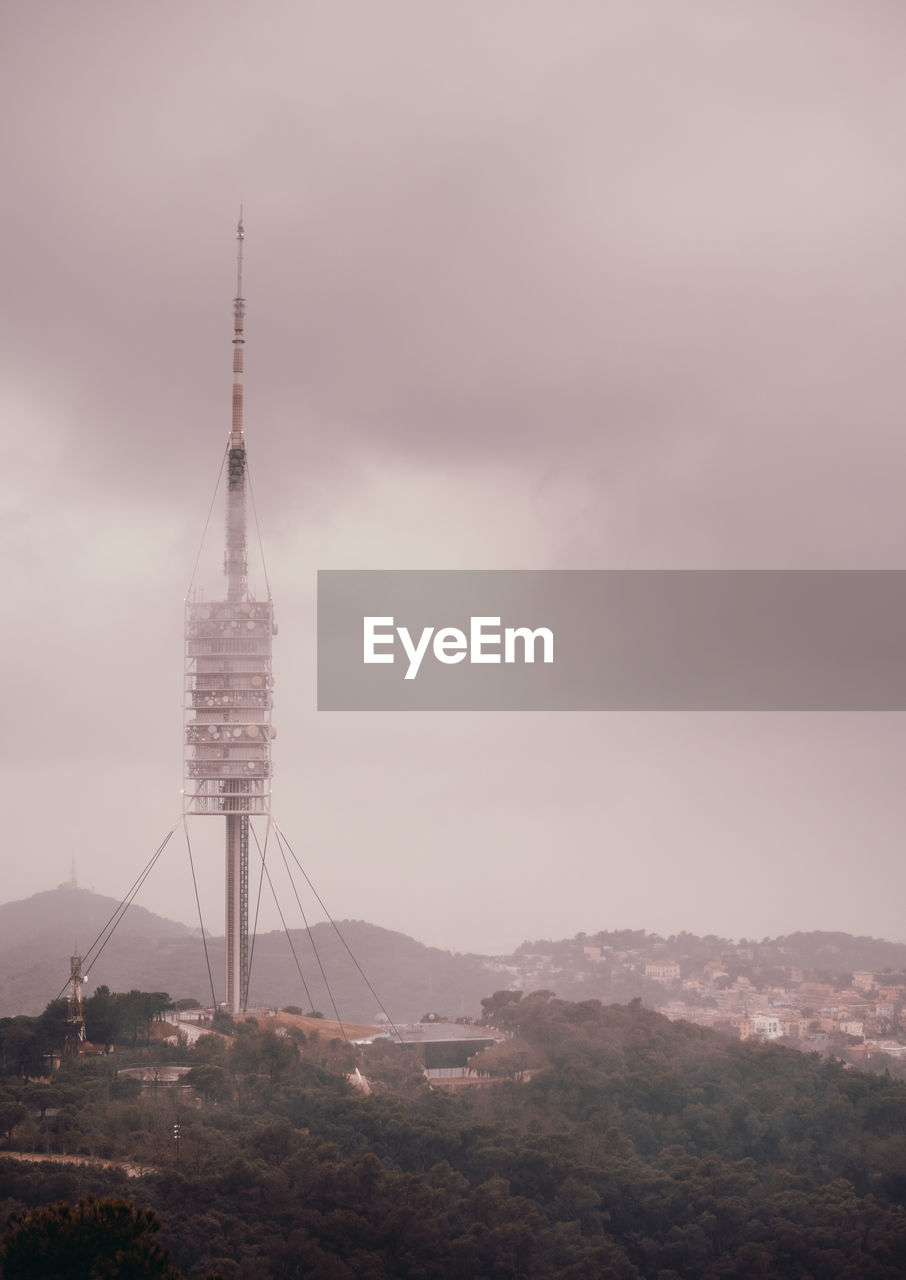 Communications tower and buildings against sky