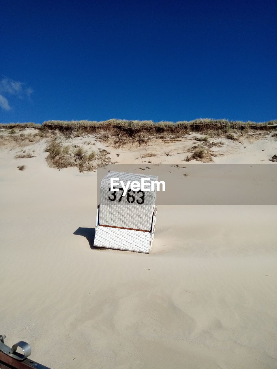 INFORMATION SIGN ON SAND AT BEACH AGAINST SKY