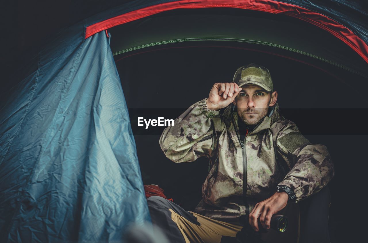 Portrait of man sitting in tent