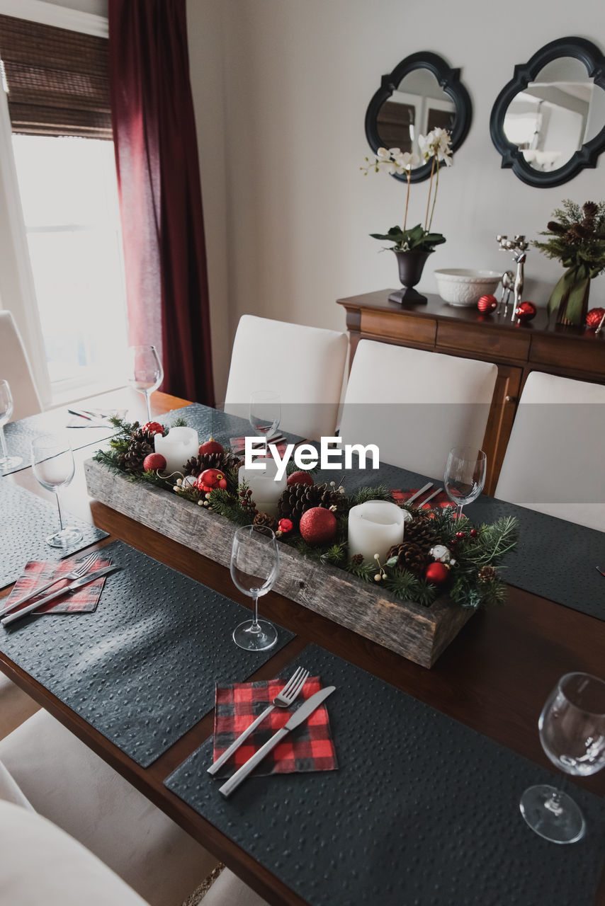 Table set for a formal christmas holiday dinner in a dining room.