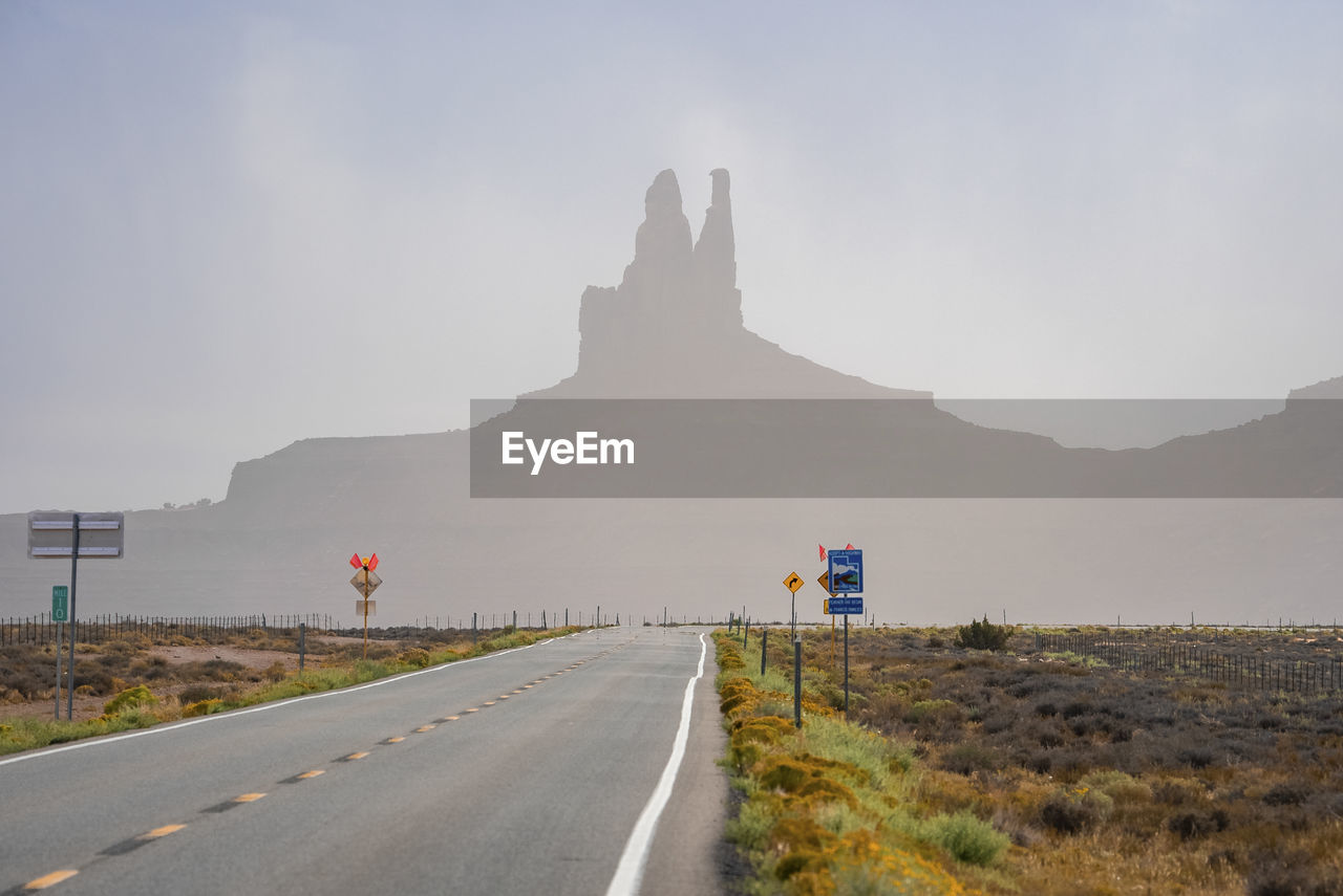 Signboards by highway leading towards geological features in monument valley