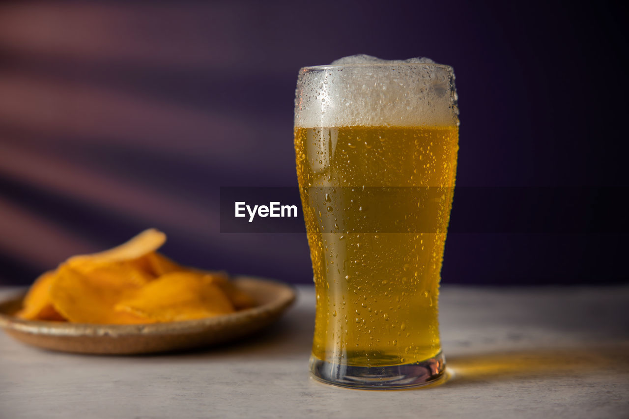 CLOSE-UP OF BEER ON GLASS TABLE