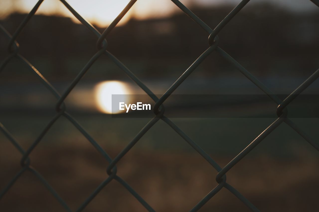 Full frame shot of chainlink fence during sunset