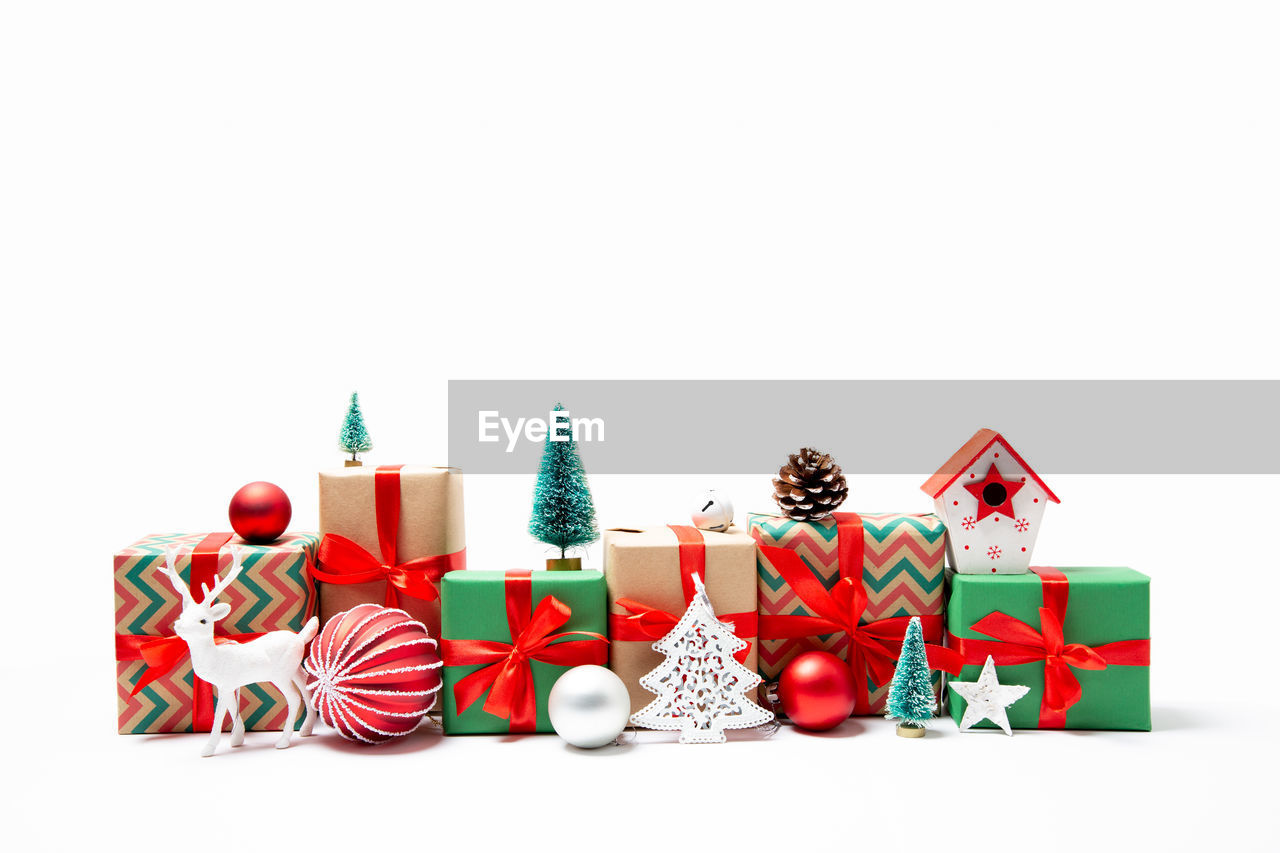 Close-up of christmas decorations and presents against white background