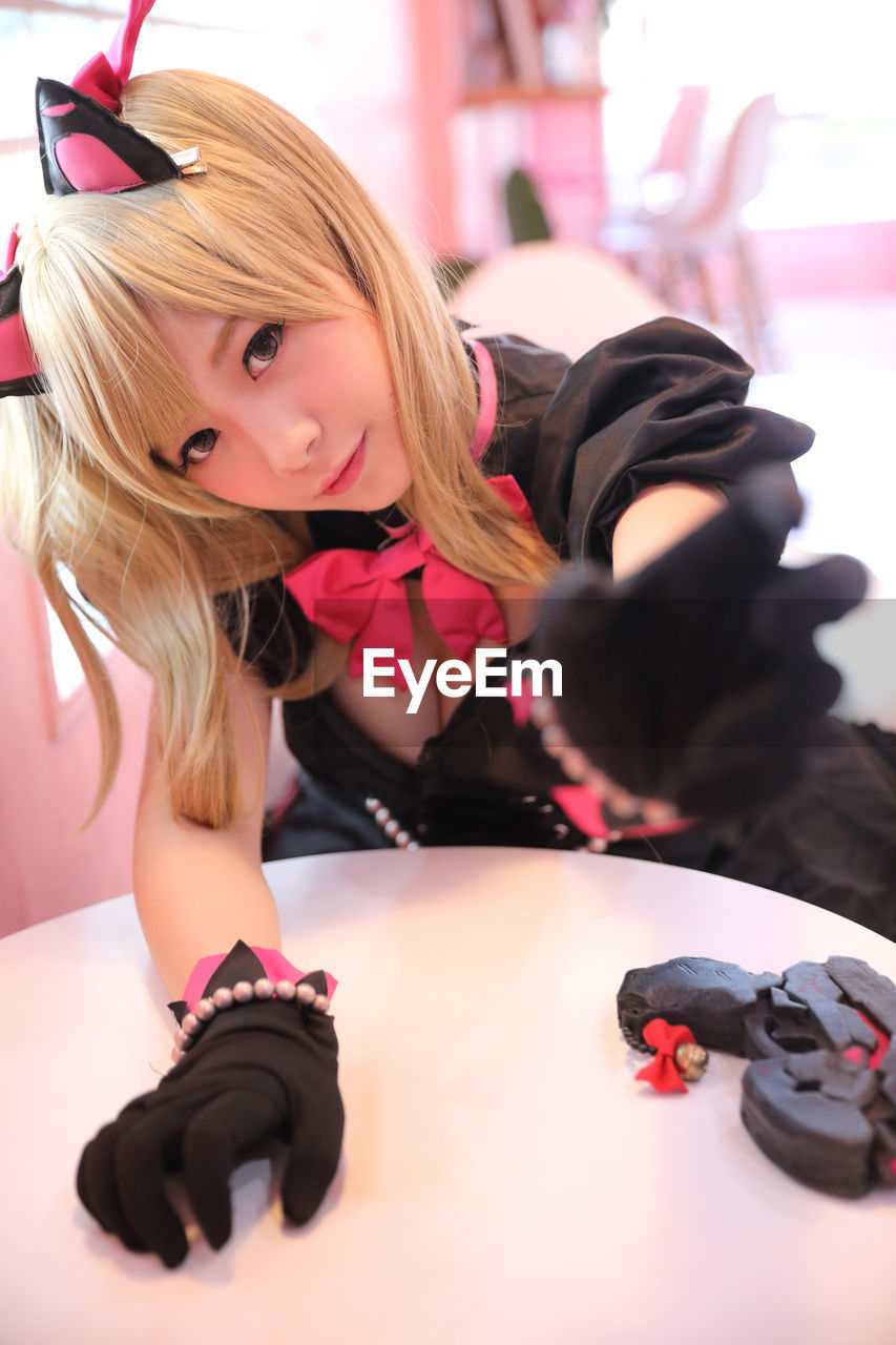 Portrait of young woman in costume sitting at cafe