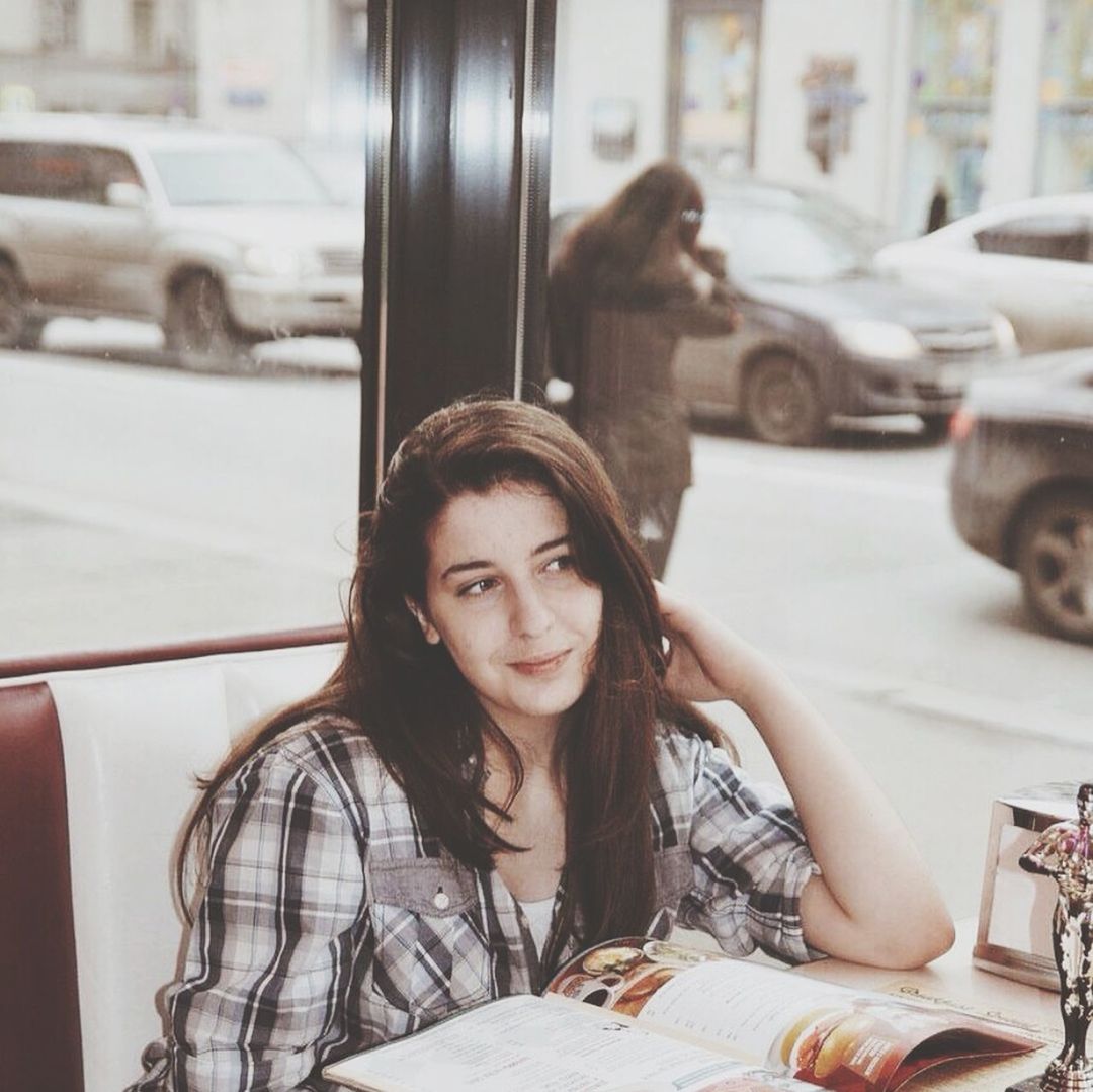 Young woman looking away while sitting at restaurant