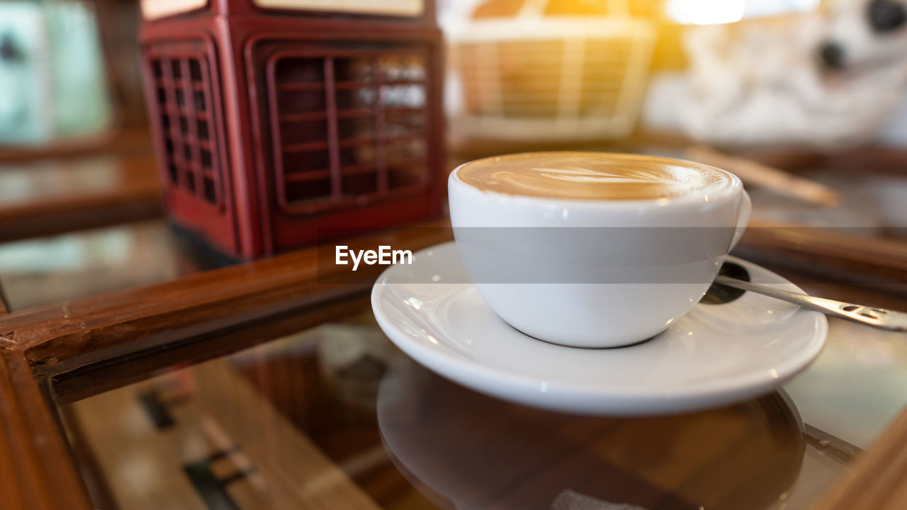 CLOSE-UP OF COFFEE CUP ON TABLE AT HOME