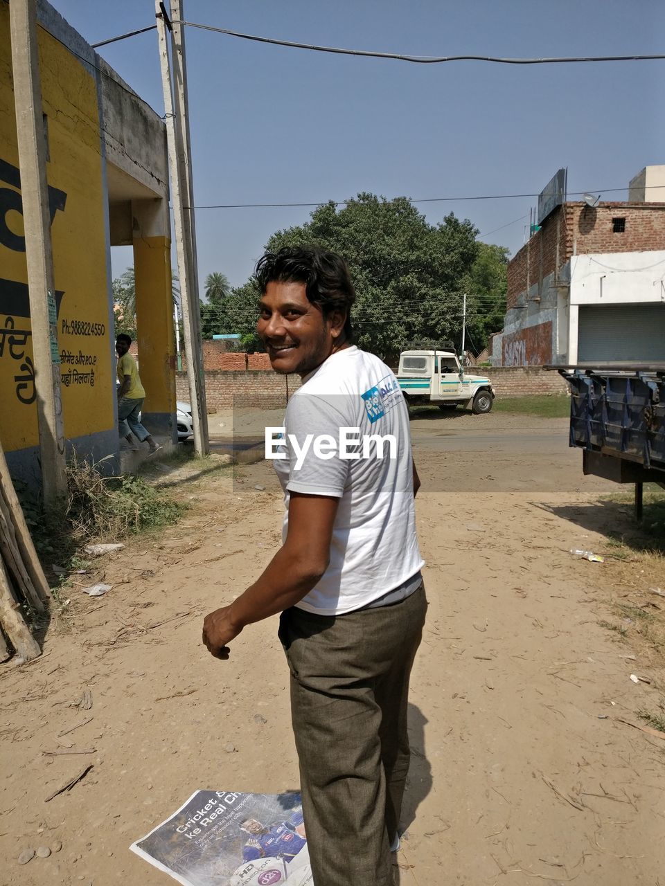 Smiling man walking on dirt road