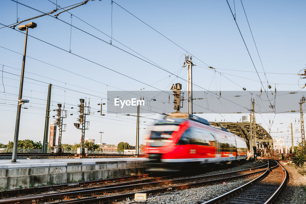 Blurred motion of train moving on railroad tracks against sky