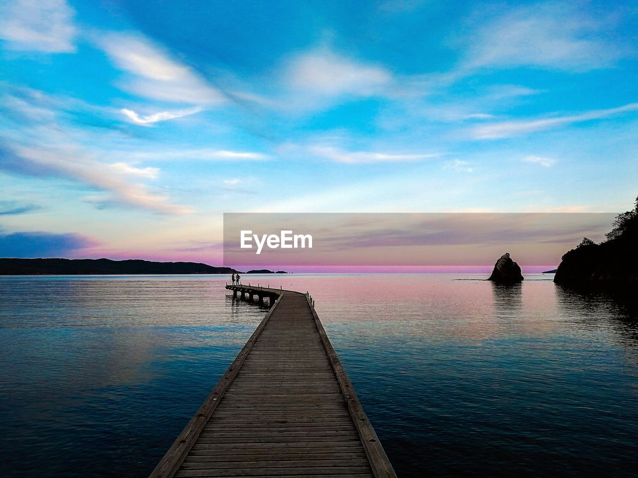 Pier over sea against sky during sunset