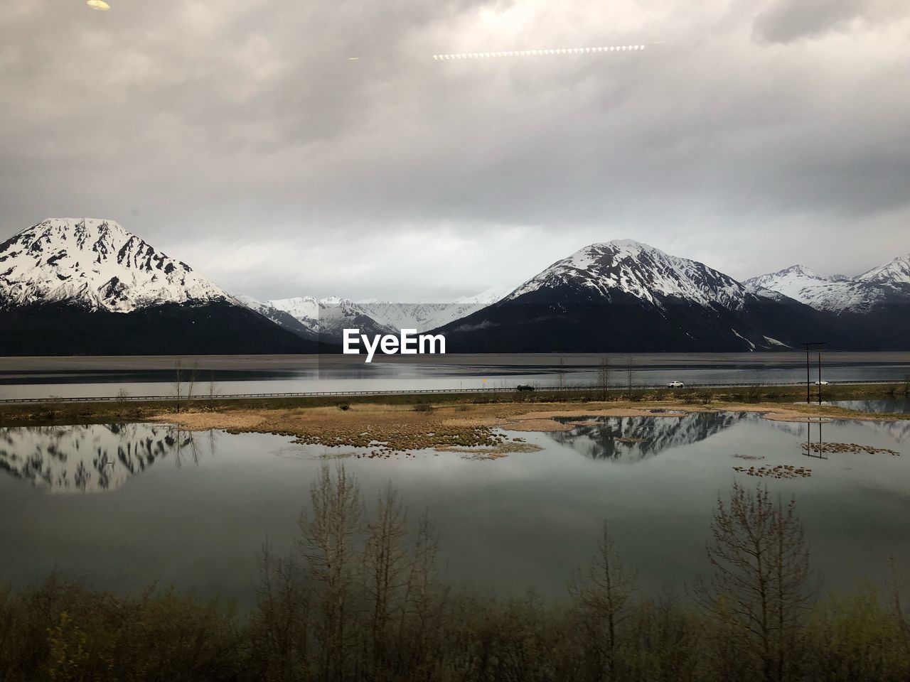 Scenic view of lake and snowcapped mountains against sky