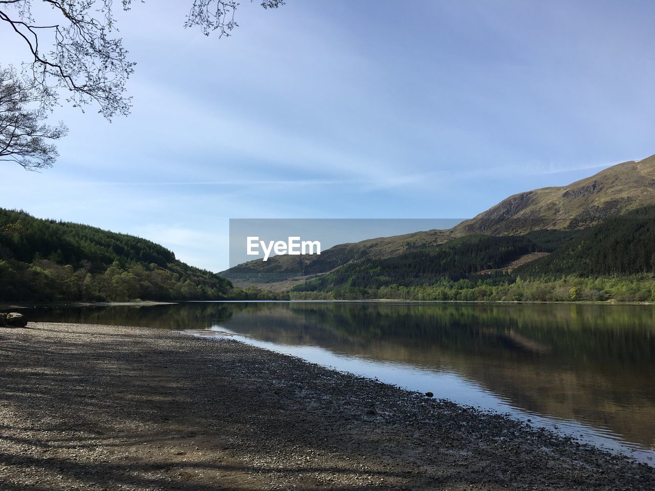 Scenic view of lake by mountains against sky
