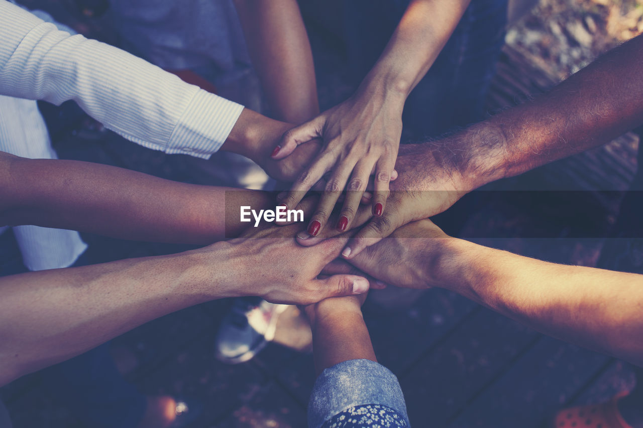 Cropped image of people stacking hands