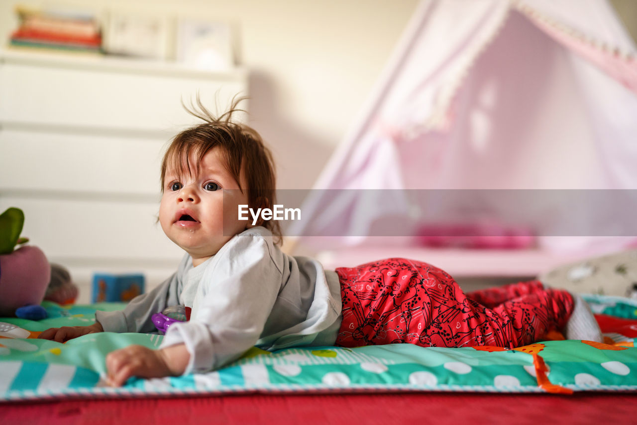 Cute baby girl lying at home