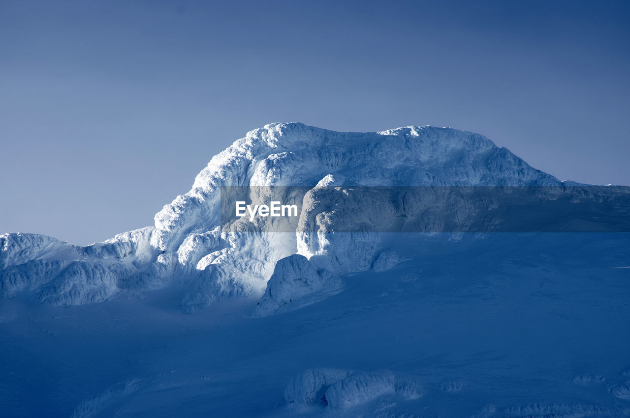 Scenic view of snowcapped mountains against clear blue sky