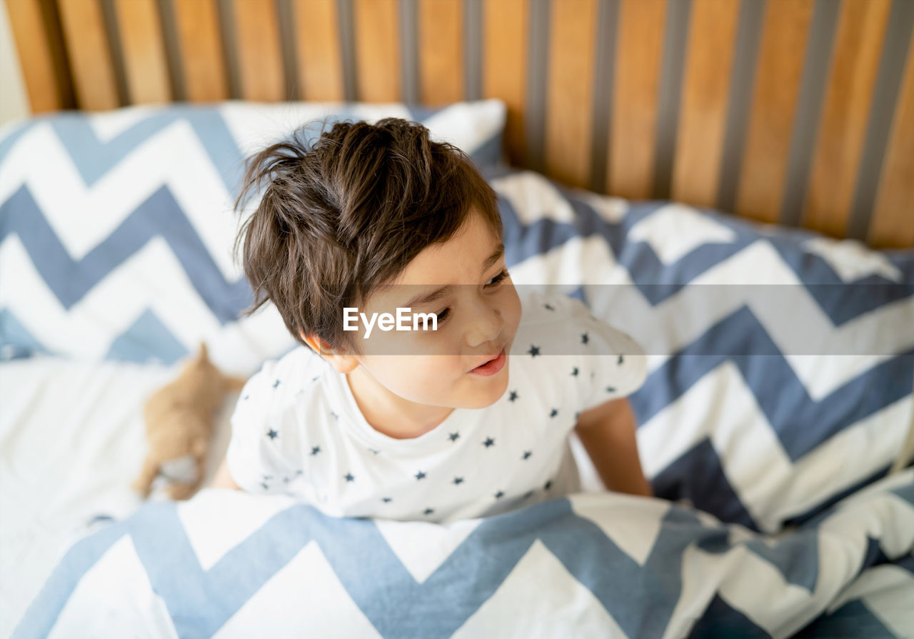 Boy lying on bed at home