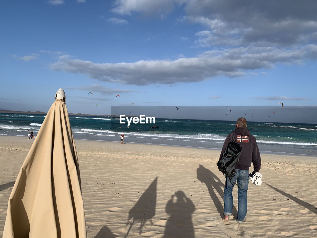 Full length of man standing on beach against sky