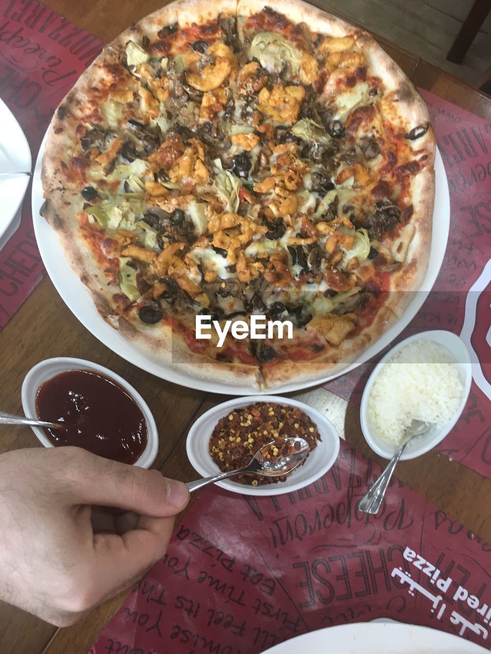 CLOSE-UP OF HAND HOLDING BOWL OF PIZZA