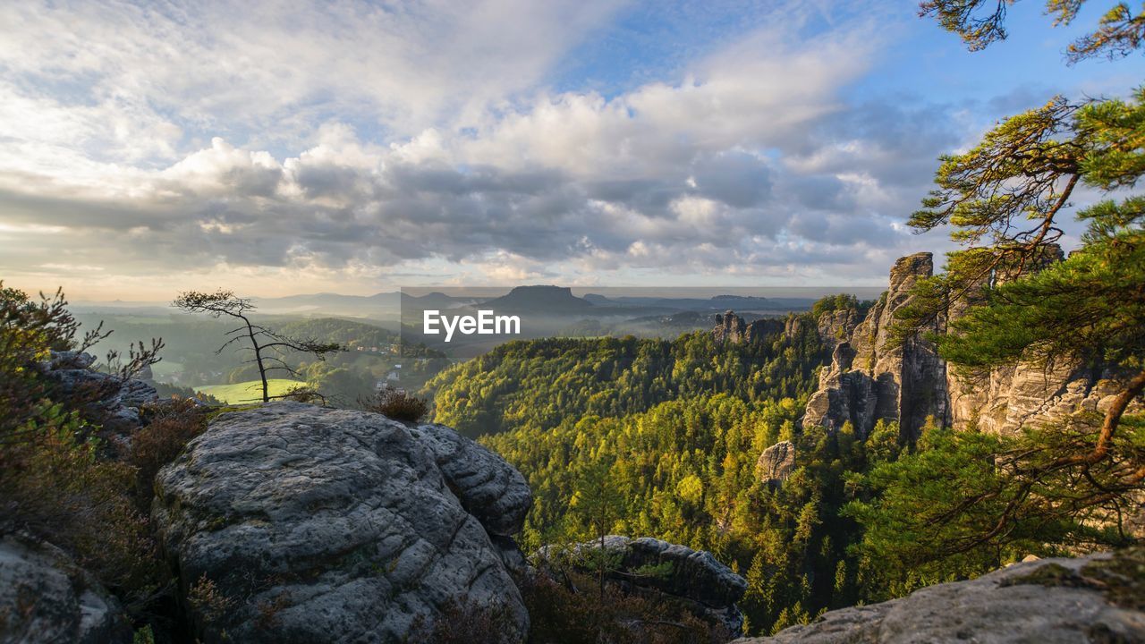 Scenic view of mountains against cloudy sky at sunset