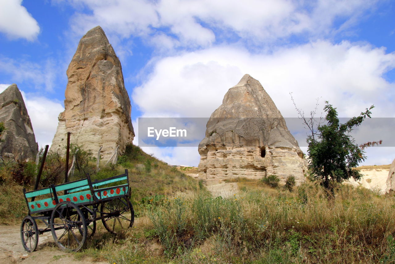 The view on the valley in the mountains with a cart on the foreground.