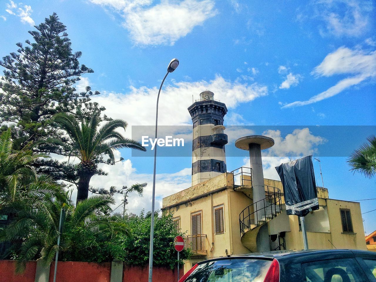 LOW ANGLE VIEW OF BUILDING AND STREET AGAINST SKY