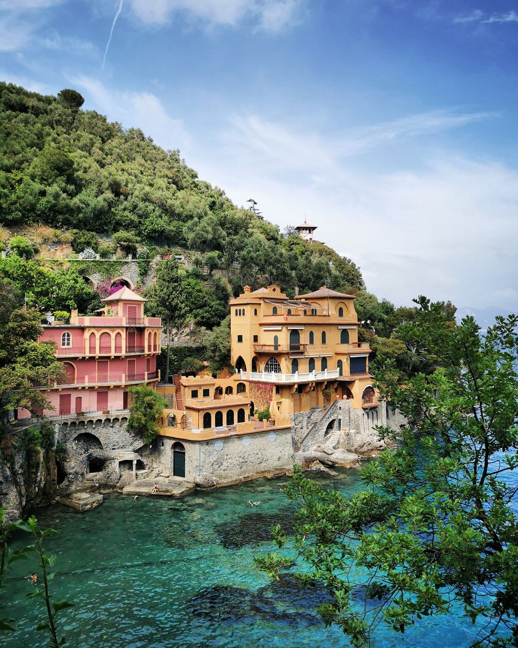 Buildings by river against sky