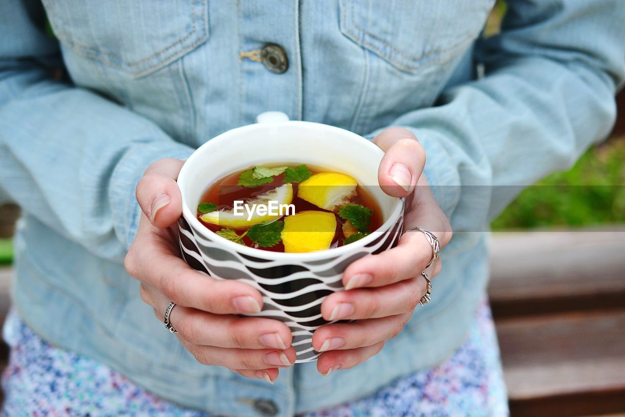 CLOSE-UP OF WOMAN HOLDING FRUIT