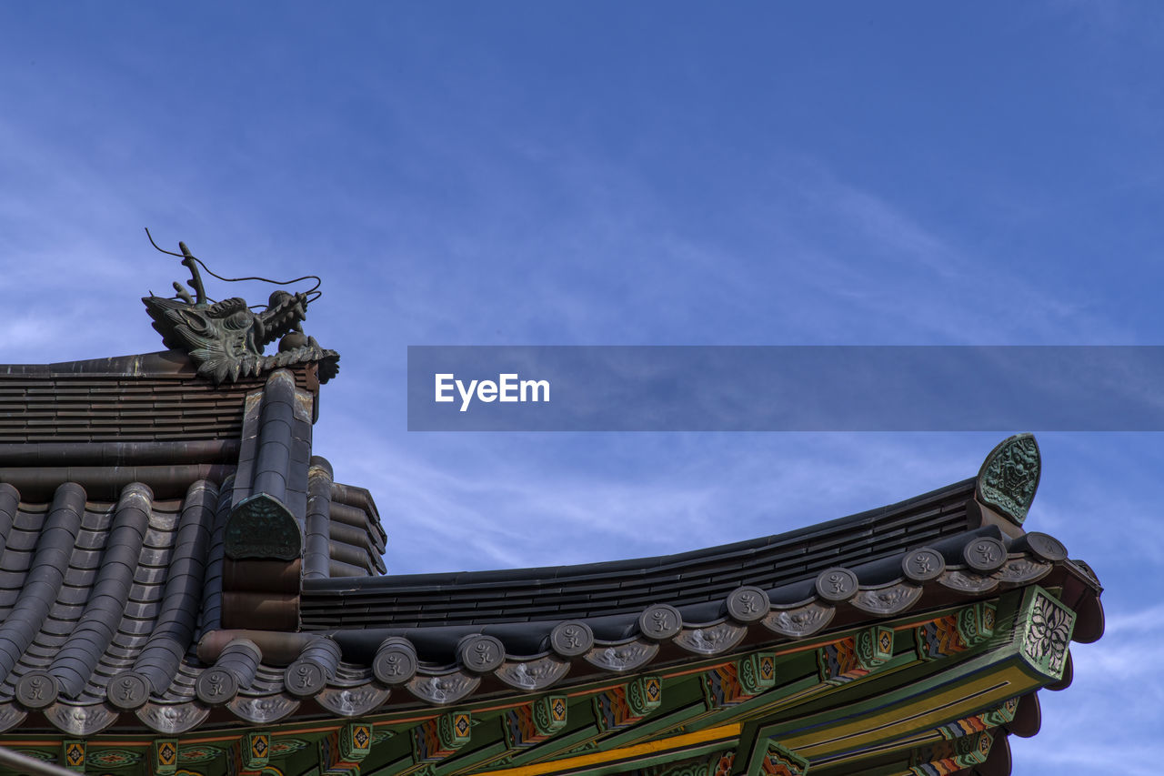 LOW ANGLE VIEW OF SCULPTURES ON ROOF OF BUILDING