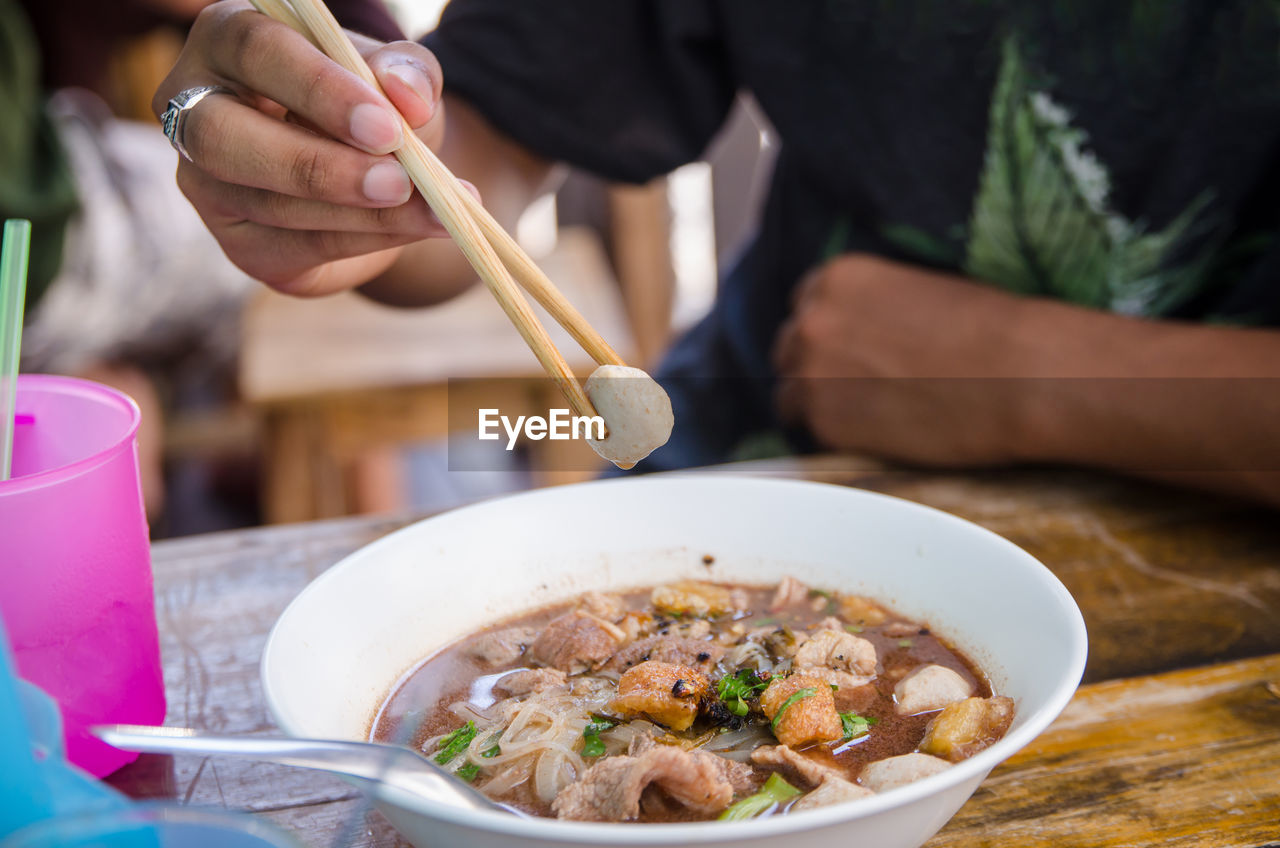 Close-up of man eating food on table