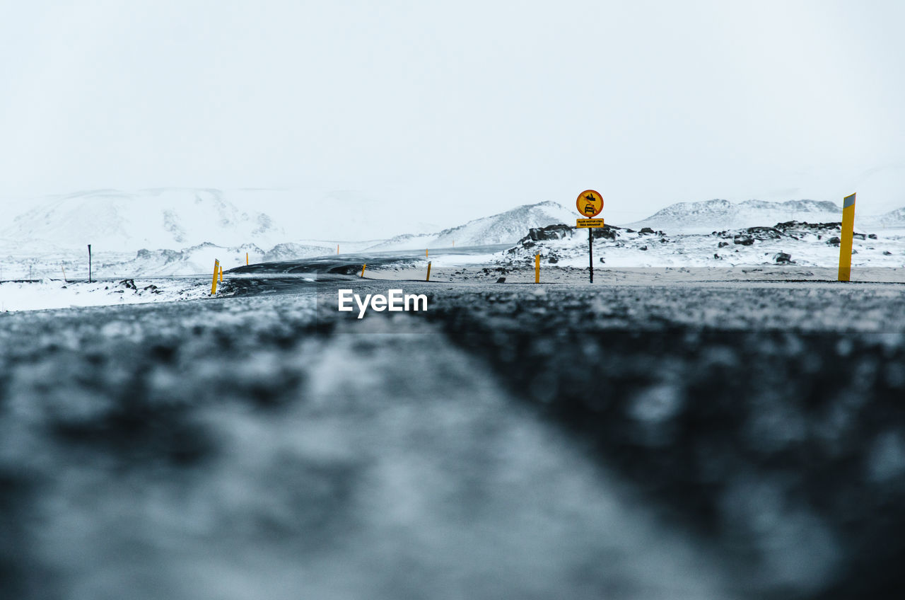 Close-up of snow on road against sky. 