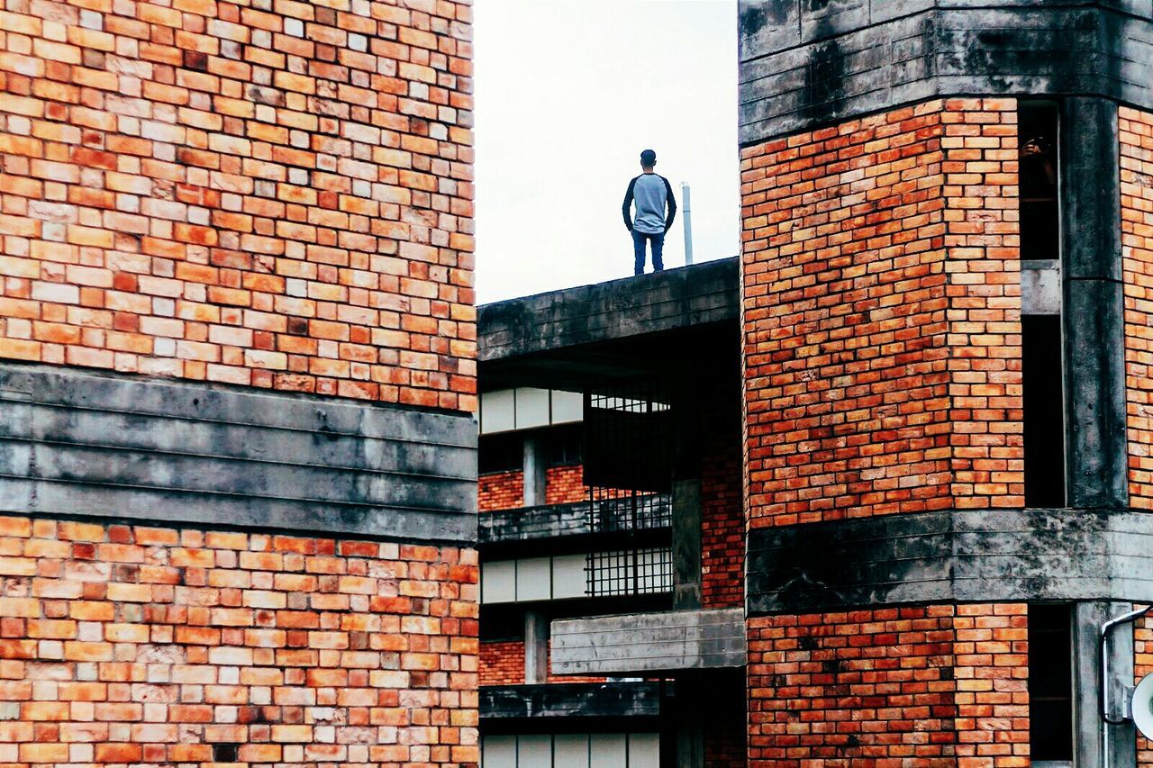 Rear view of man standing on building terrace