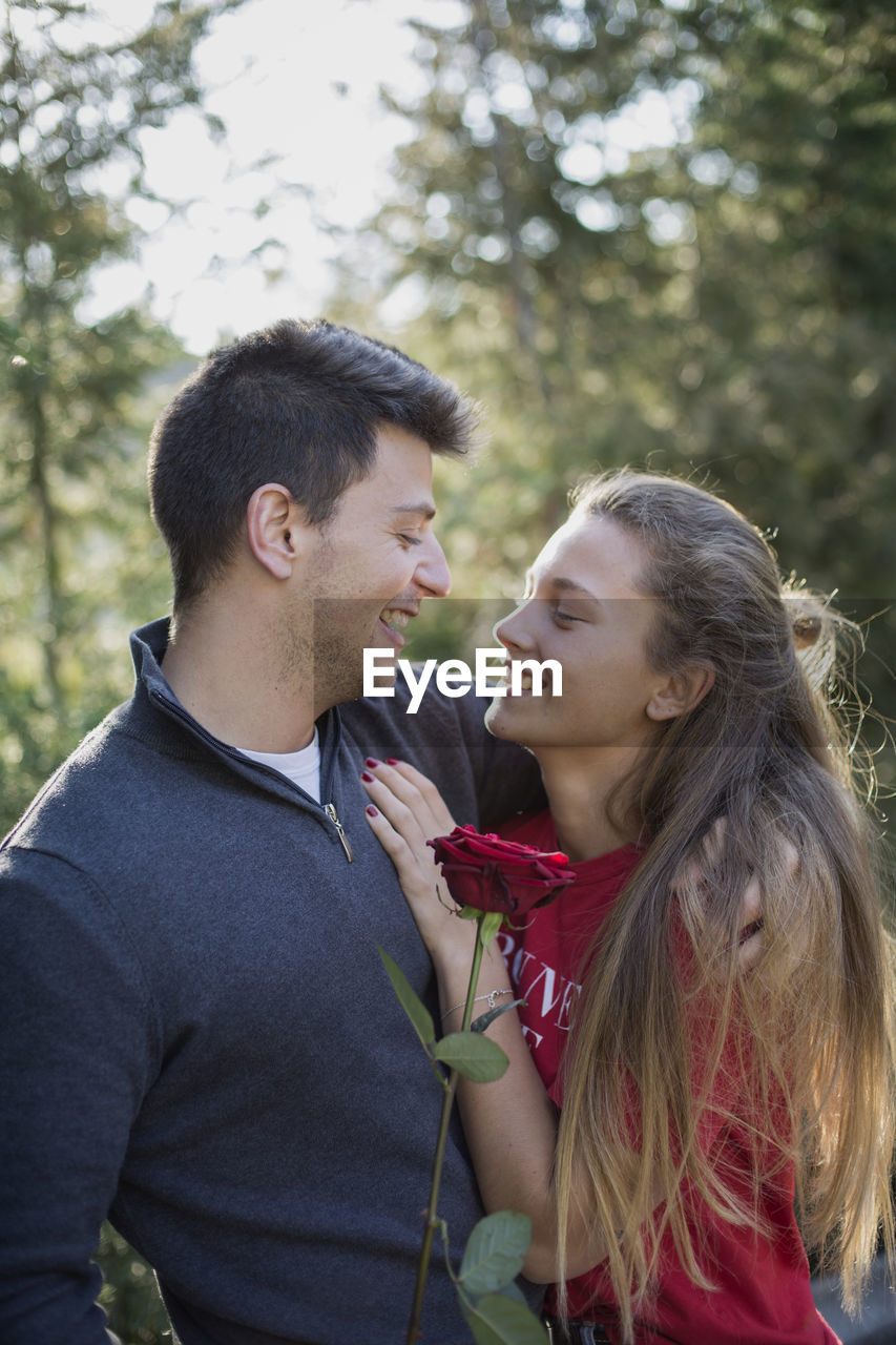 COUPLE KISSING AGAINST BLURRED BACKGROUND