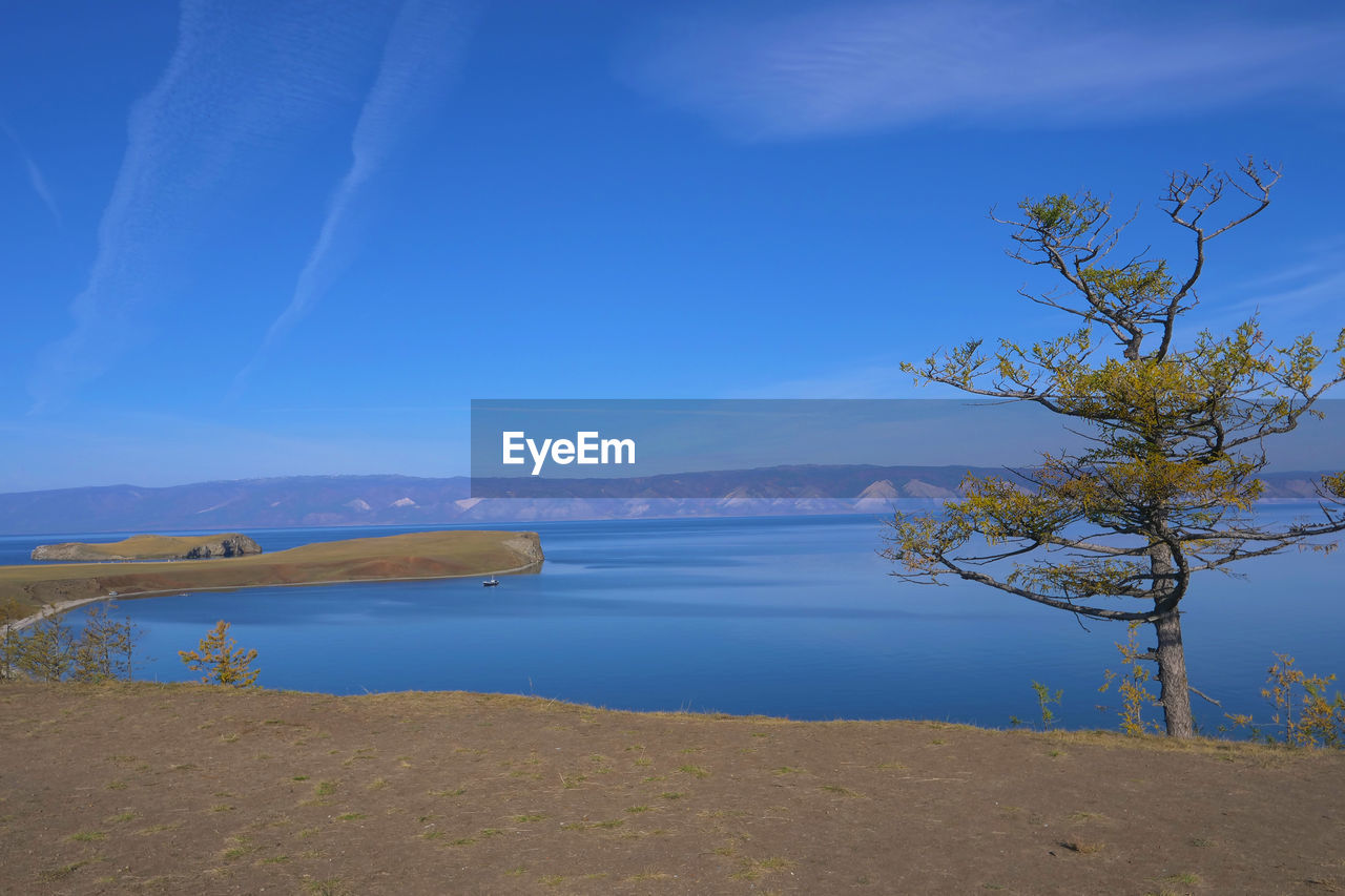 SCENIC VIEW OF LAKE BY MOUNTAIN AGAINST BLUE SKY