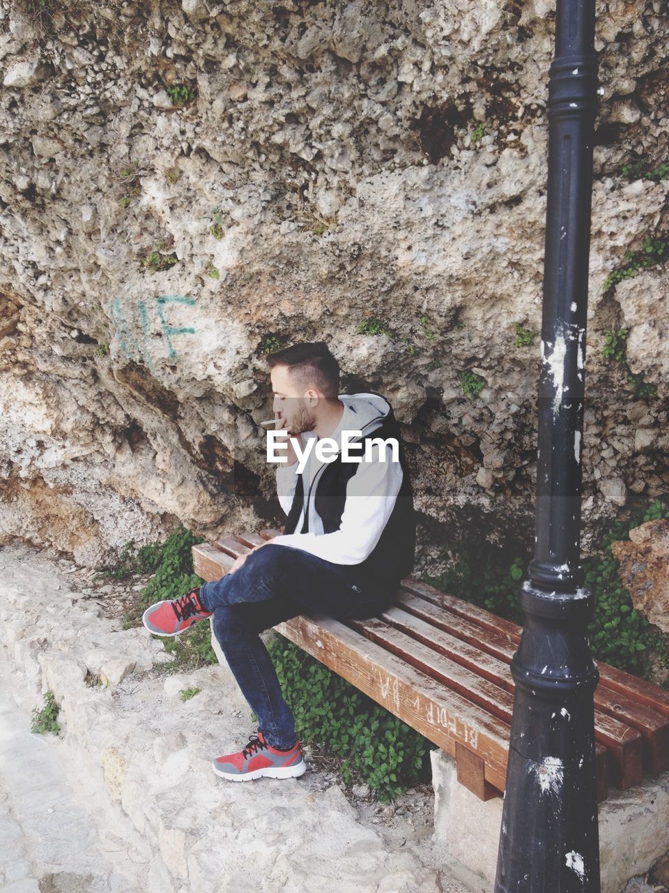 FULL LENGTH OF GIRL SITTING ON WALL