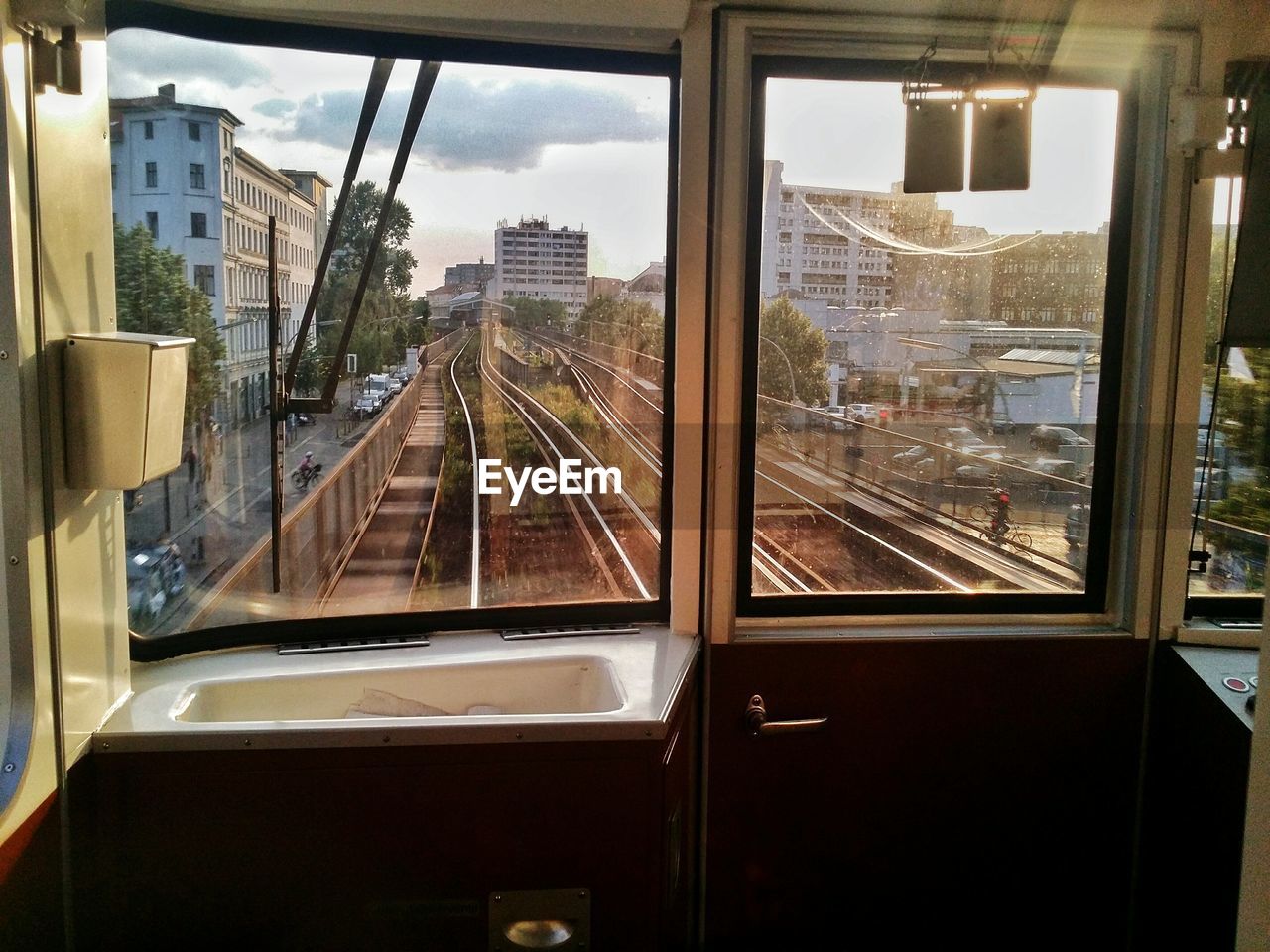 Railroad tracks amidst buildings seen through train window