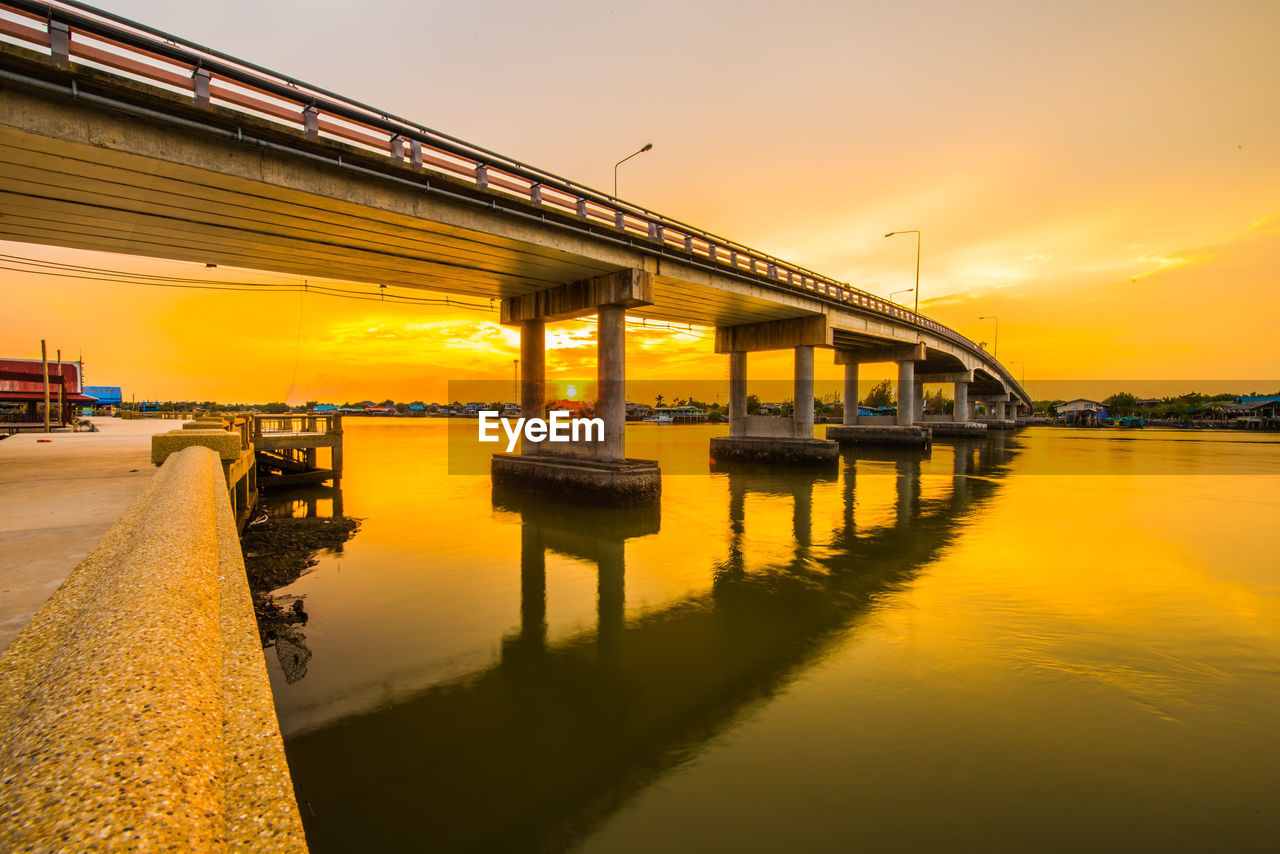 Bridge over river against sky during sunset