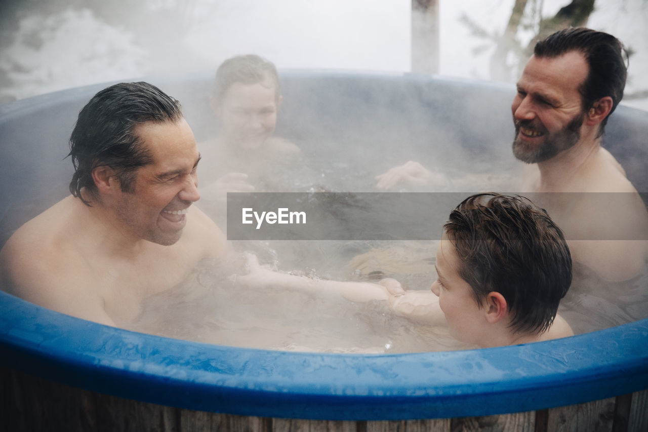 Cheerful families enjoying together in hot tub